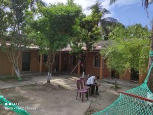 a man sitting on a chair in front of a house at Jarif st. Martin eco resort in Jaliapāra