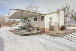 een huis met een overdekte veranda in de sneeuw bij Roomy Cedar City Home Fenced Yard, Pets Welcome! in Cedar City
