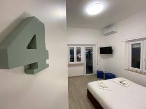 ein Zimmer mit einer großen Nummer vier an der Wand in der Unterkunft Le casette di Frà Host and Go in Santa Severa