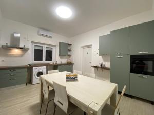 a kitchen with a table and chairs in it at Le casette di Frà Host and Go in Santa Severa +74 photos