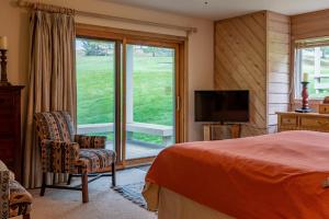 1 dormitorio con 1 cama, TV y ventana en Sunburst Condo 2739 - Warmly Updated, Leather Furniture and Mountain Views en Elkhorn Village