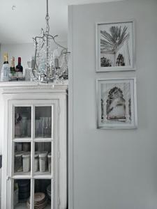 a white cabinet with two pictures on top of it at Kaupunkikoti erinomaisella sijainnilla in Porvoo +1 photo
