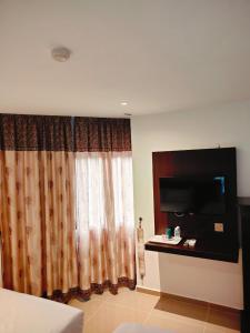 Pokój hotelowy z zasłoną i telewizorem w obiekcie One Dream Hotel w mieście Petaling Jaya