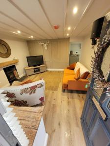 salon z kanapą i telewizorem w obiekcie Charming 1-Bed Cottage in Brynmenyn w mieście Bridgend