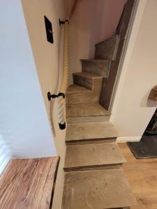 a wooden staircase with a rope on the wall at Charming 1-Bed Cottage in Brynmenyn in Bridgend