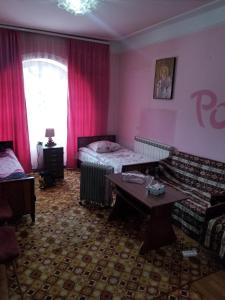a room with a bed and a couch and a table at Guest House Dompolski in Gyumri