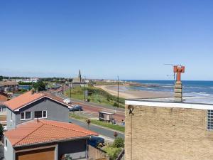 a view of a beach and a building and the ocean at Longsands Beach, Apartment 4, Tynemouth in Tynemouth