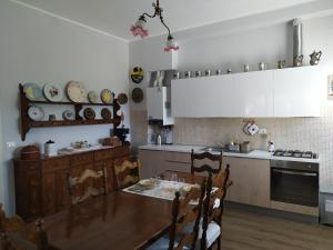 uma cozinha com uma mesa e uma cozinha com armários brancos em Casa Vacanze I Giardini di Marzo em San Giorgio Di Mantova