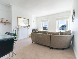a living room with a couch and two windows at Longsands Beach, Apartment 4, Tynemouth in Tynemouth