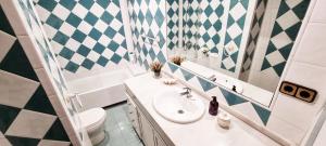 a bathroom with a sink and a toilet and a mirror at Vivienda con fines turísticos "Casa Paquita" in Andújar +10 photos