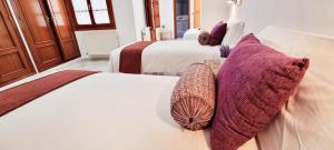 two beds with pillows on them in a room at Vivienda con fines turísticos "Casa Paquita" in Andújar