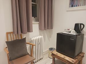 a room with a chair and a television and a radiator at Number Five in Brighton & Hove