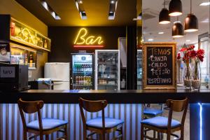 um bar com cadeiras num restaurante com um balcão de bar em Tarobá Hotel em Foz do Iguaçu