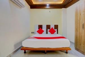 a bedroom with a bed with red pillows on it at Super OYO Flagship Hotel Family Deluxe in New Delhi