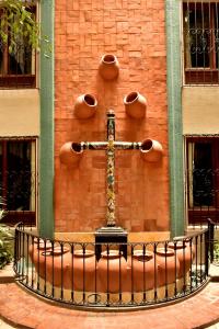 サン・クリストバル・デ・ラス・カサスにあるホテル マンション デル ヴァレのレンガ造りの建物の横十字架