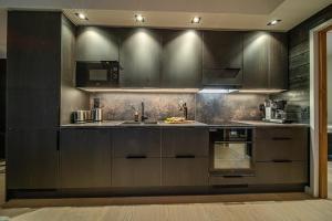 a kitchen with dark brown cabinets and a sink at Slopeside Bliss C21 Levi Center by Aavalevi in Levi