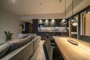 a living room with a couch and a wooden table at Slopeside Bliss C21 Levi Center by Aavalevi in Levi