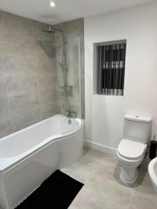 a bathroom with a tub and a toilet and a sink at Coatham house in Redcar