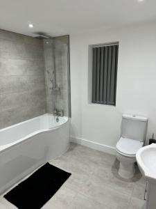 a bathroom with a tub and a toilet and a sink at Coatham house in Redcar