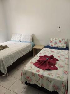 a bedroom with two beds and a robe on the bed at Flat Pé de Mamão in Campinas