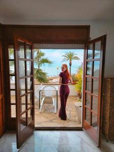 Una donna in piedi sulla porta di una casa di Villa Jo - stunning front line beach house. a L'Ametlla de Mar