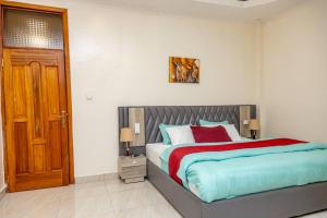 a bedroom with a bed and a wooden door at KIGALI GREET HOTEL in Kigali