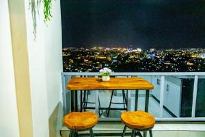 d'une table et de deux tabourets sur un balcon avec vue. dans l'établissement KIGALI GREET HOTEL, à Kigali