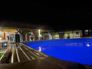 a large blue swimming pool at night at Agroturystyka DANA in Debrzno