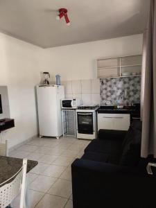 a living room with a couch and a kitchen at Flat Pé de Mamão in Campinas