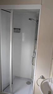 une douche avec une porte en verre à côté d'un lavabo dans l'établissement 51 oaklands, à Cowes