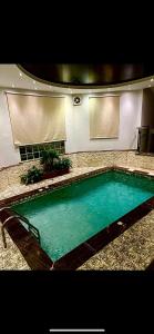 a large swimming pool in a building with at فيلا توينز in Taif