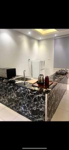 a kitchen with a black counter top with a sink at فيلا توينز in Taif