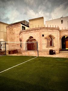 a large brick building with a tennis court at فيلا توينز in Taif