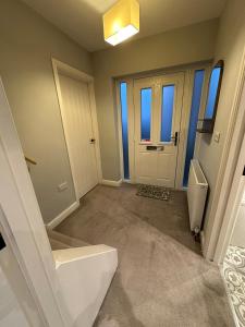 an empty room with a door and a toilet at Elwood - spacious contemporary home from home in Harrogate with parking in Harrogate