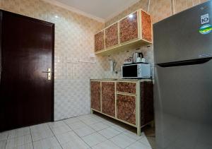 a small kitchen with a refrigerator and a microwave at MAJESTIC HOTEL APARTMENTSماجستيك للشقق الفندقيه in Kuwait