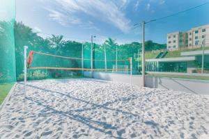 um campo de voleibol com uma rede na areia em Apê a 3 min praia de Cotovelo em Parnamirim