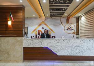 un hombre hablando en un podio en un vestíbulo en MAJESTIC HOTEL APARTMENTSماجستيك للشقق الفندقيه, en Kuwait