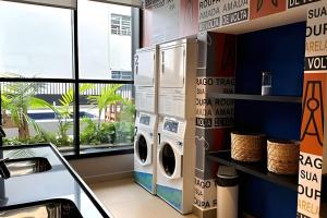 eine Waschküche mit zwei Waschmaschinen und einem Fenster in der Unterkunft Sampa Sky Particular: Vista Única no Último Andar in São Paulo