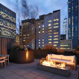 a couch sitting on a patio with a fire place at Central New York residence in New York