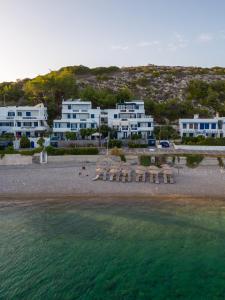 eine Luftansicht auf einen Strand mit weißen Gebäuden in der Unterkunft Chios Xenia Studios & Apartments in Paralia Agias Foteinis