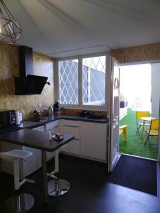 a kitchen with a counter and a table and some chairs at Studio, La terrasse d'Isa in Dole