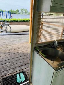 parę klapek siedzących na zlewie kuchennym w obiekcie Aqua Beach House w mieście Oudehaske