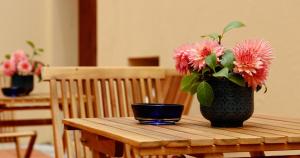 un jarrón con flores rosas sentado en una mesa de madera en Quinta da Nasce Água, en Angra do Heroísmo