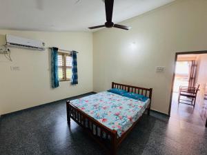 um quarto com uma cama e uma ventoinha de tecto em Seaview Homestay Padubidri em Padubidri