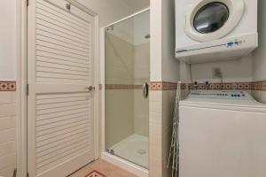 a bathroom with a shower and a washing machine at AWSA On the Water Luxury (4003) in Auckland
