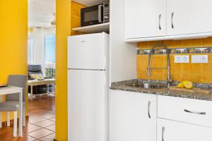 uma cozinha com um frigorífico branco e um lavatório em Cosy, seaview apartment, close to beach and bars -Edificio RHIN em Campoamor
