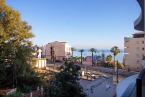 a view of a city street with palm trees and the ocean at Sea View Apartment Near The Beach in Fuengirola