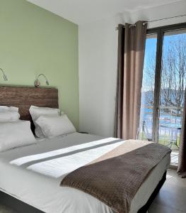 ピナールルにあるHôtel du Golfe Pinarelloのベッドルーム1室(大きなベッド1台、大きな窓付)