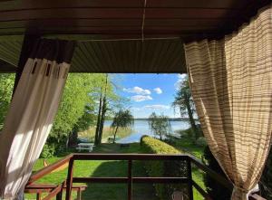 a view from a screened in porch with a view of a lake at Dom nad brzegiem Jeziora in Augustów