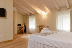 a bedroom with a white bed and a desk at Relais Ca' Morenica in Valeggio sul Mincio +135 photos